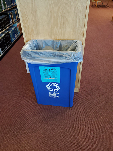 a recycling bin with a label displaying what should and should not be disposed of in the bin