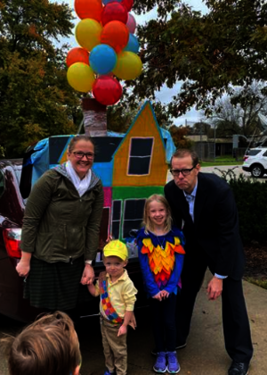 family dressed like the characters from Disney's "Up" in front of their decorated car