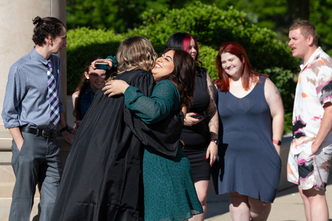 a female graduate hugging family