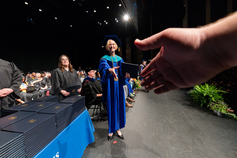 point of view of graduate receiving degree from the chancellor on stage