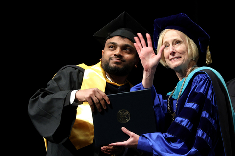 graduate posing with chancellor for photo