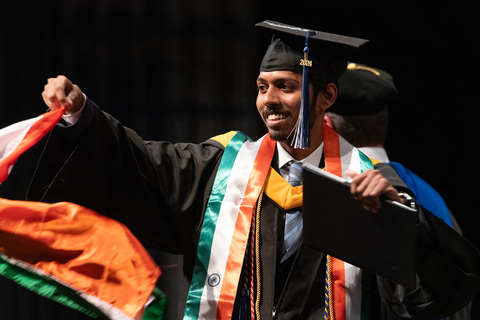 a graduate proudly waving the Indian flag on stag as he gets his degree