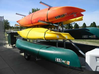 Kayaks and canoes on a pull behind trailer.