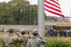 the american flag being raised at UIS with veterans saluting it