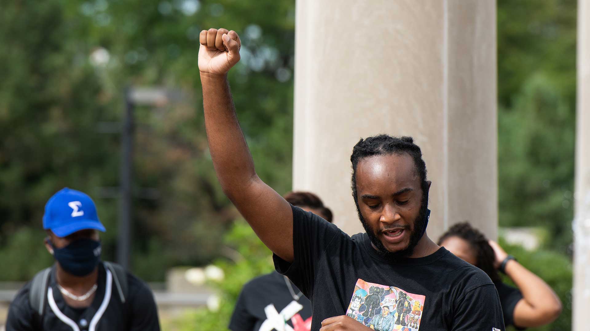 student throwing his fist up in the air for solidarity