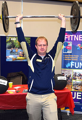 staff lifing weights above head like a strongman