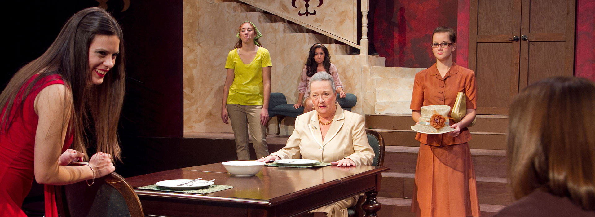 six people in a play on a stage interacting with each other