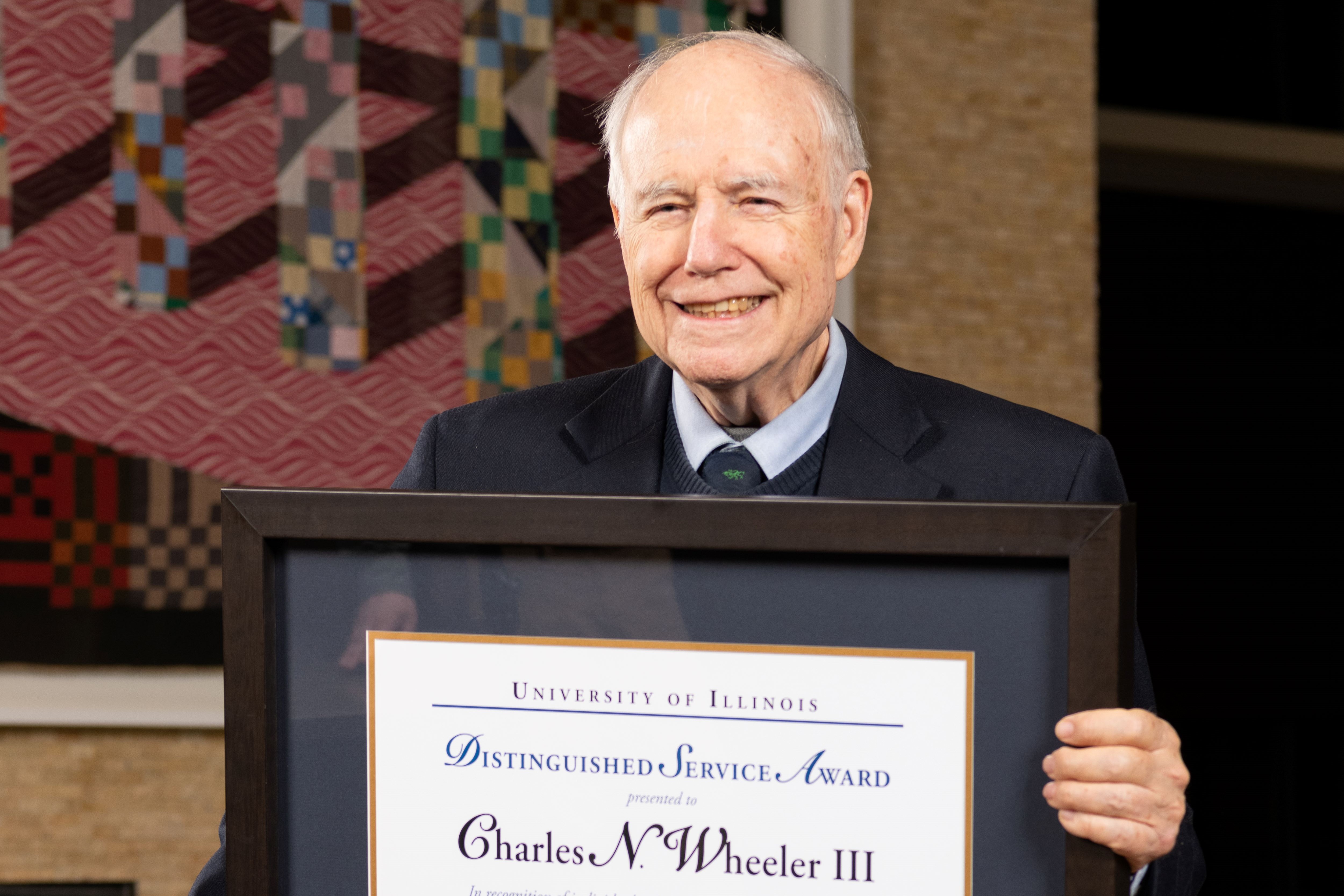 Charlie Wheeler holding his Distinguished Service Award