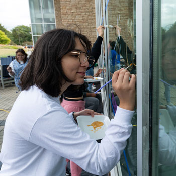 student writing on a window