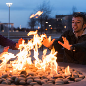 students warming hands at fire