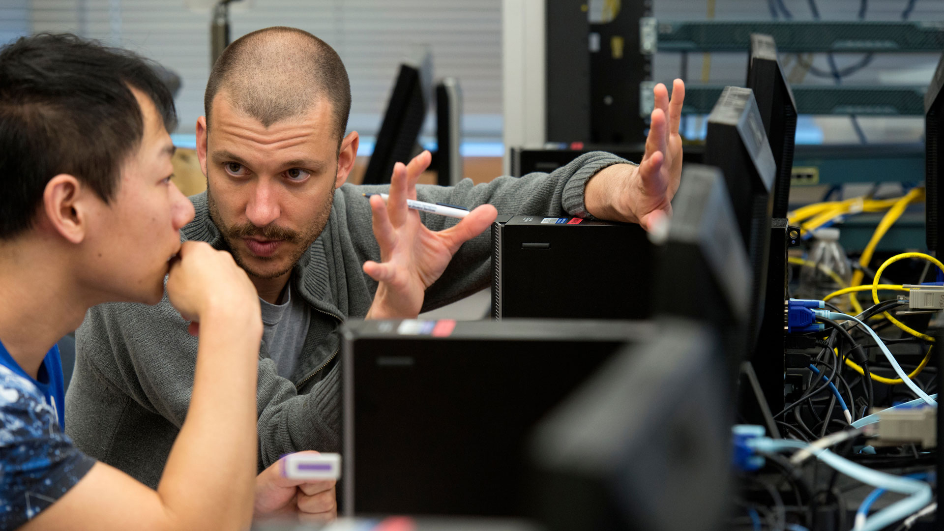 a professor explaining something on a computer to a student