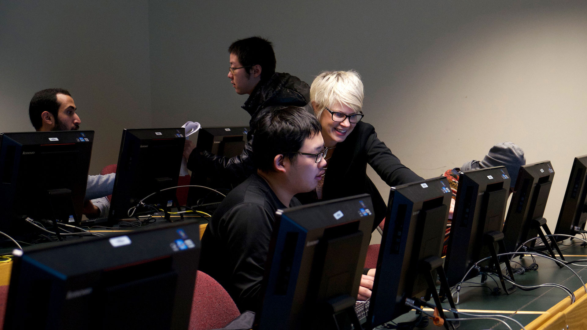 a professor explaining something on a computer to a student