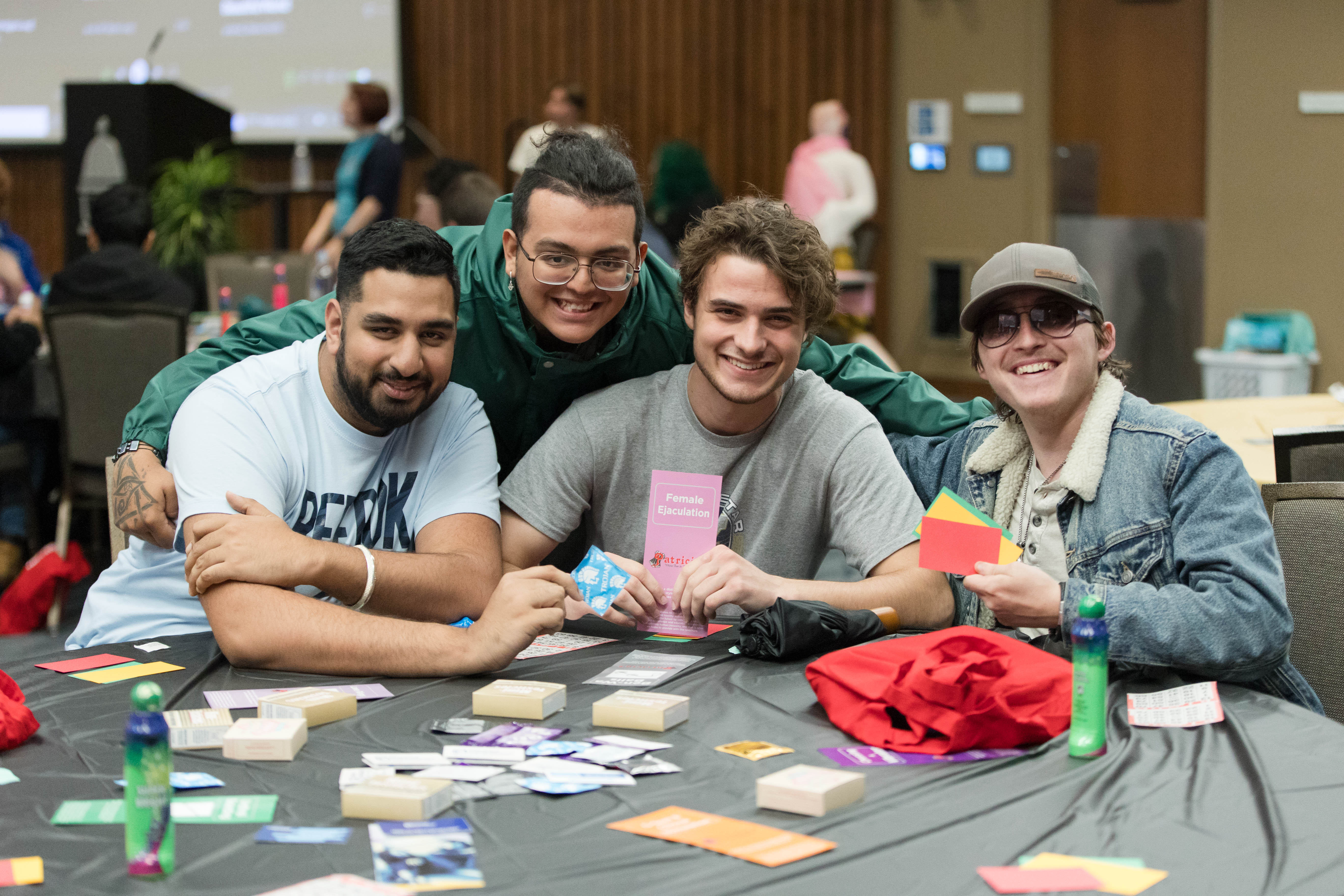Four people posing with Bingo supplies at a table.