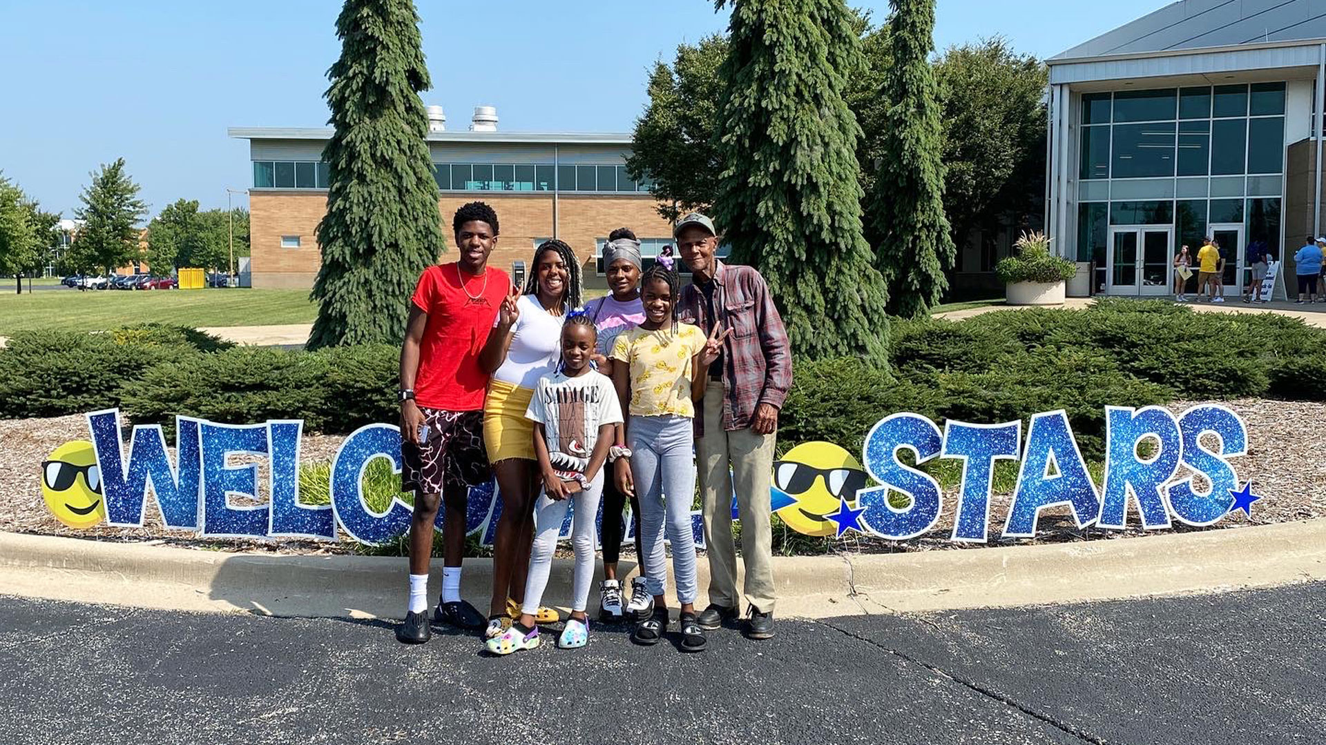 a UIS student and his family posing for a picture in front of TRAC
