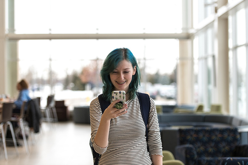 Student using mobile phone in campus building