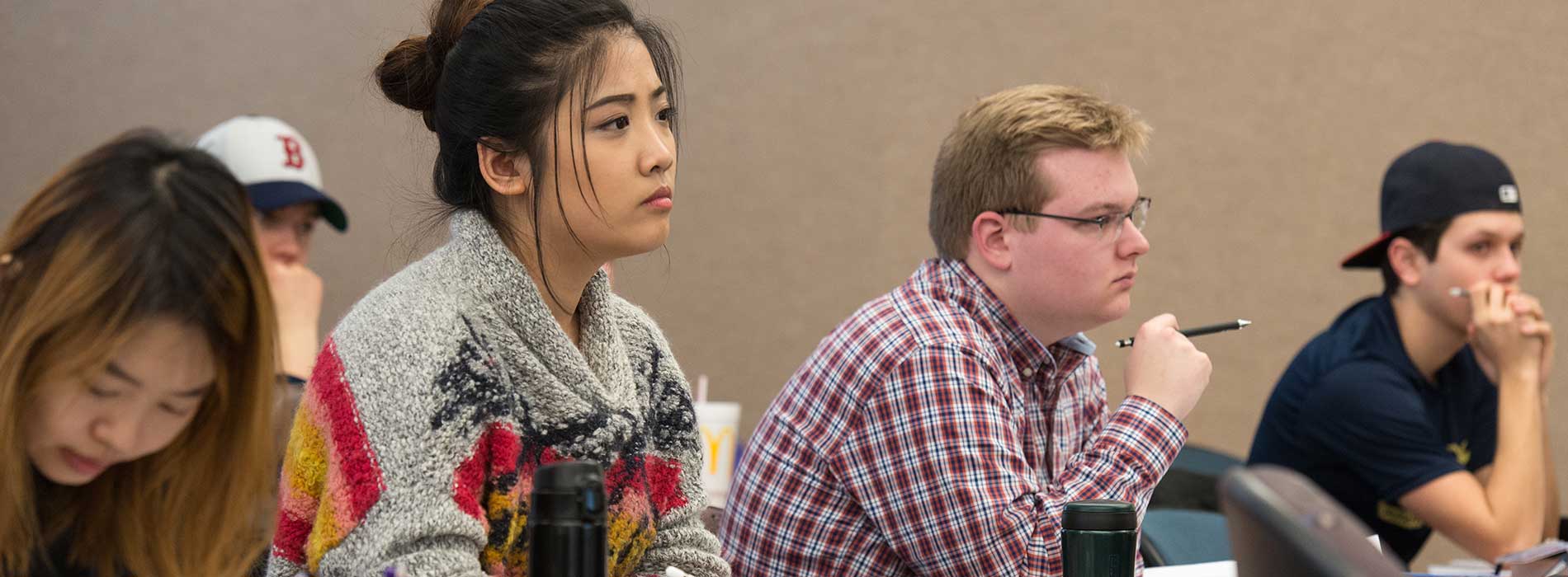 Students in a classroom attentively taking notes.