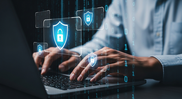 Hands typing on a laptop with digital security icons.