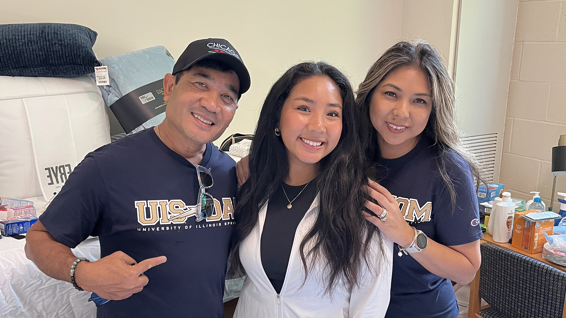 a student and her parents moving her in to her new room on campus