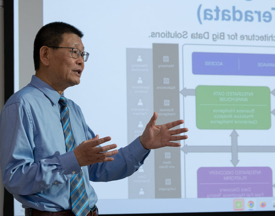 Man presenting data flowchart on screen.