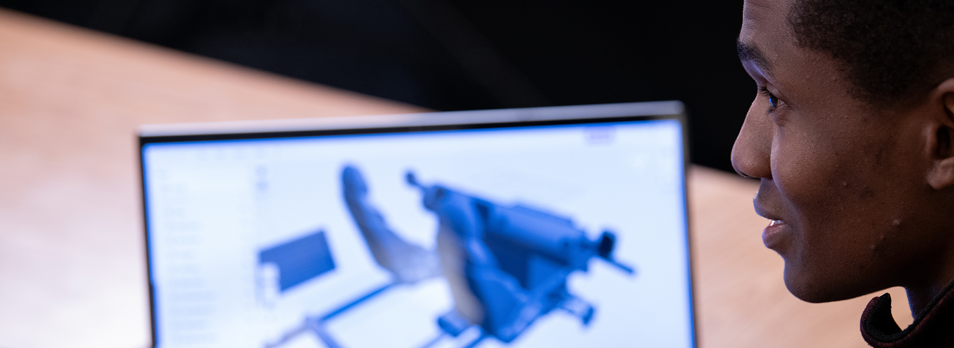 Person viewing 3D model on laptop screen.