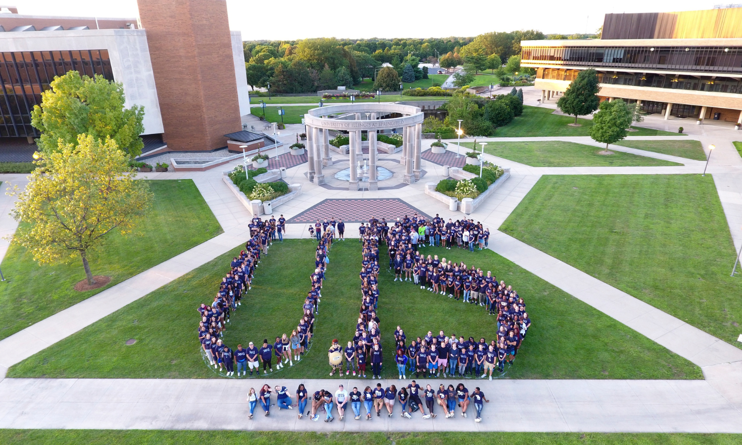 UIS class of 2023 forming the letters "UIS" in front of colonnade.