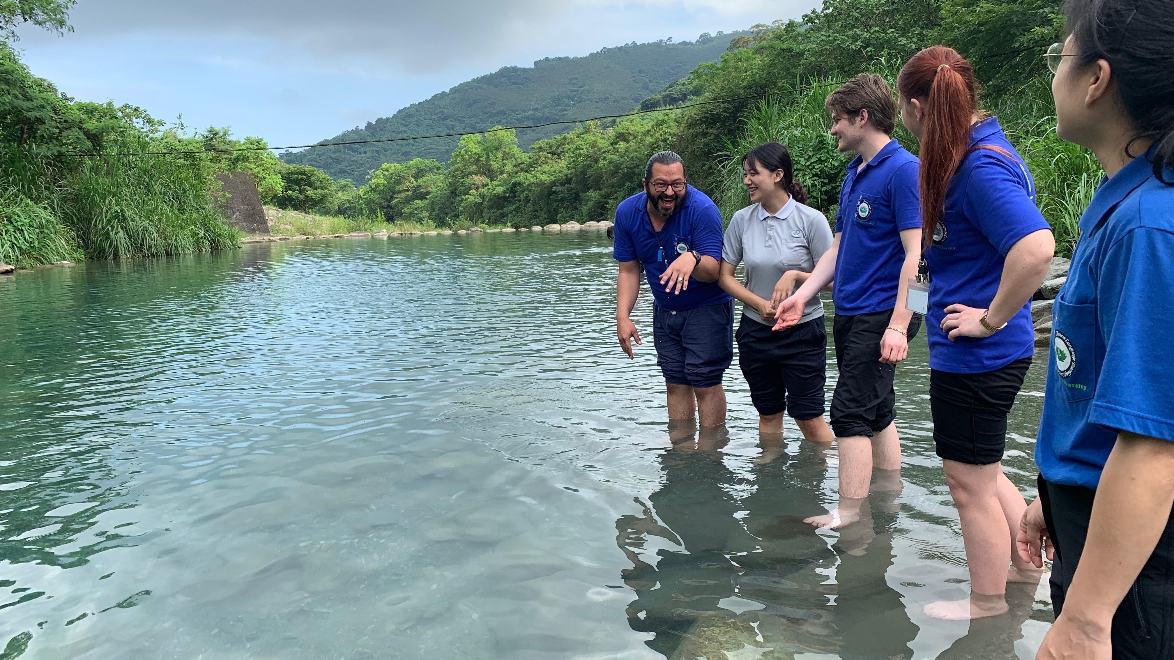 Students wading in a mountain pond.