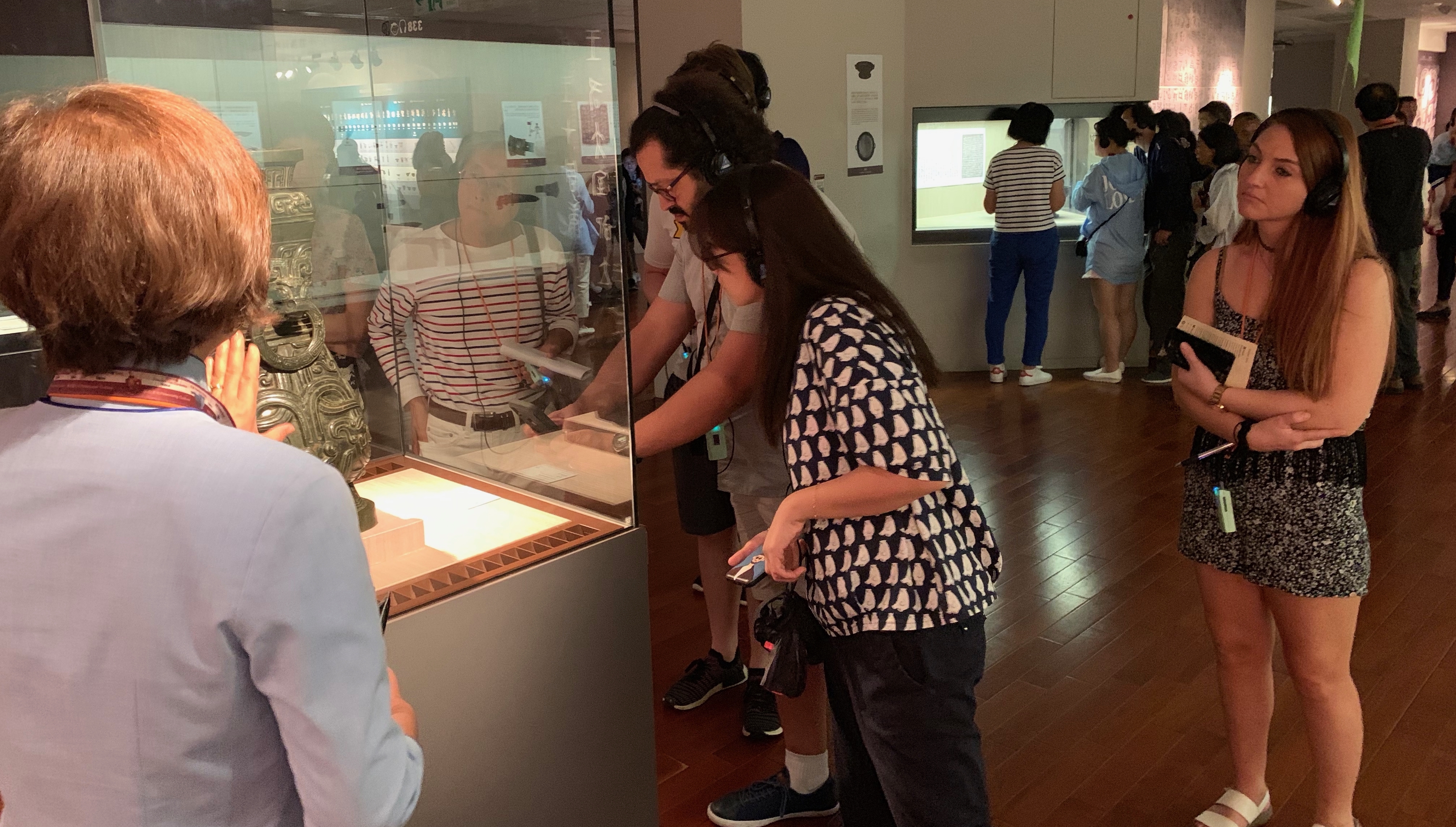 Students look at an ancient artifact displayed in an art museum