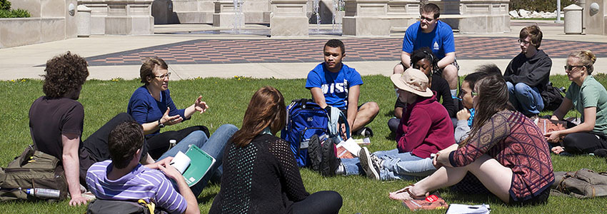 A group of students sits on the quad.