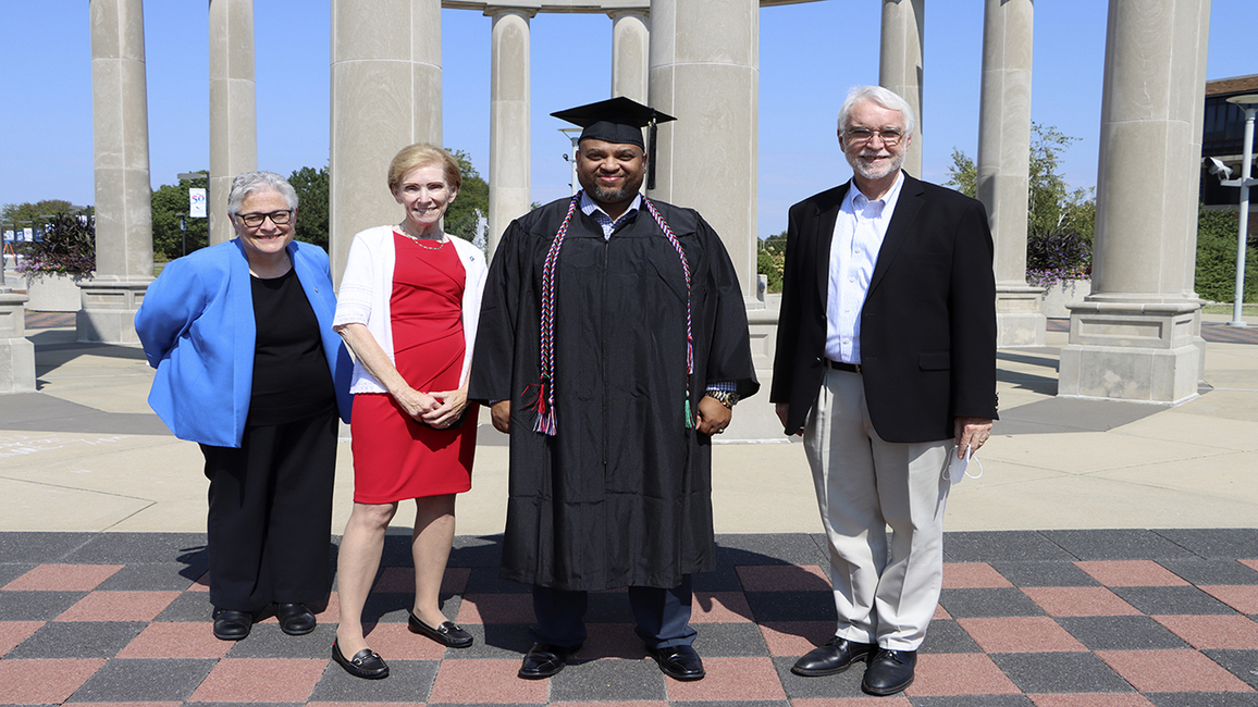 UIS Graduate Christopher Holley poses with UIS Interim Chancellor Karen Whitney, Chancellor Emerita Susan Koch and UI System President Timothy Killeen on Sept. 18 during the 2020 Commencement Ceremony.    