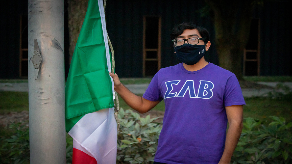 Edgar Gasca takes part in the flag raising ceremony during Hispanic/LatinX Heritage Month at UIS.