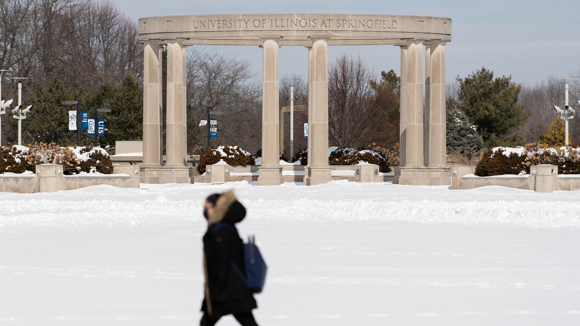 Snow covered UIS campus, student walking