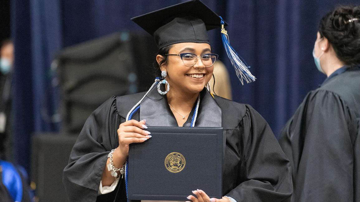 Graduate holding diploma cover