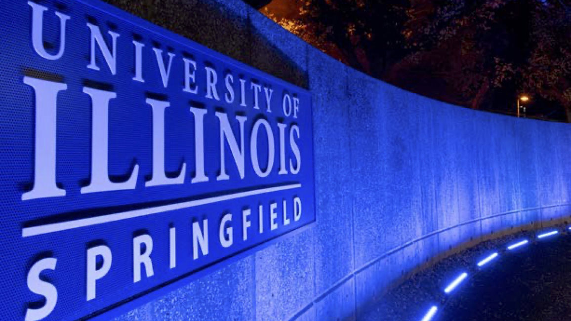 UIS signage highlighted in blue lights at night