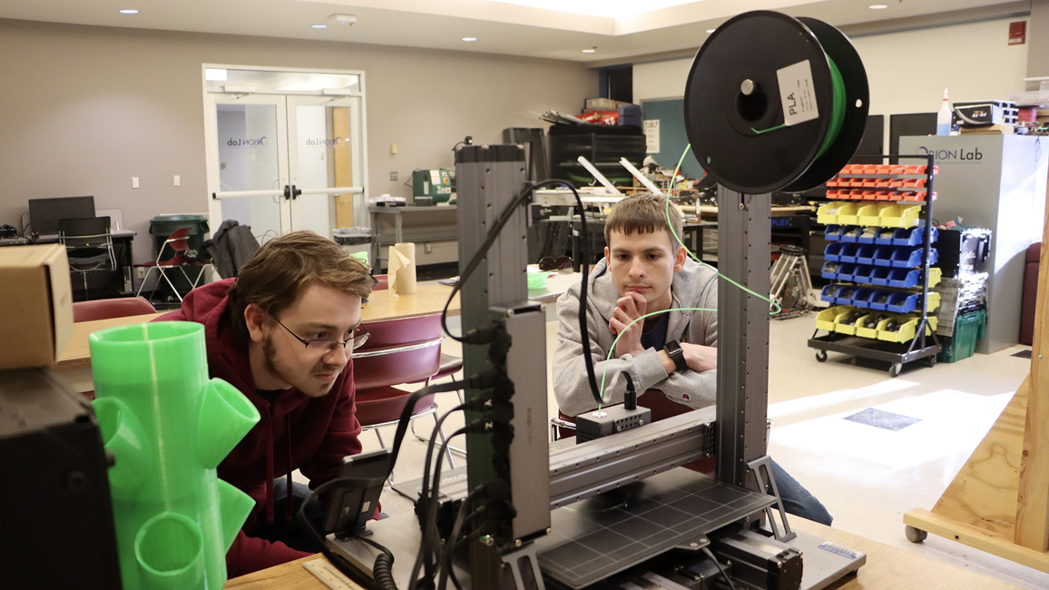 Students working on a 3D printer in the lab