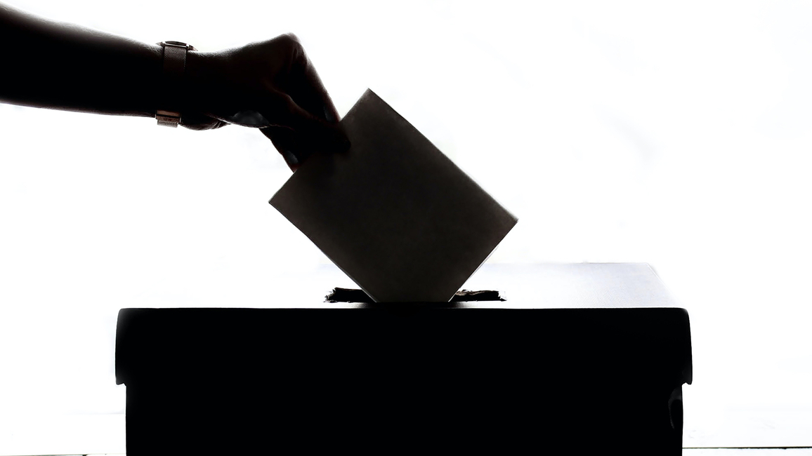 Hand putting ballot in box