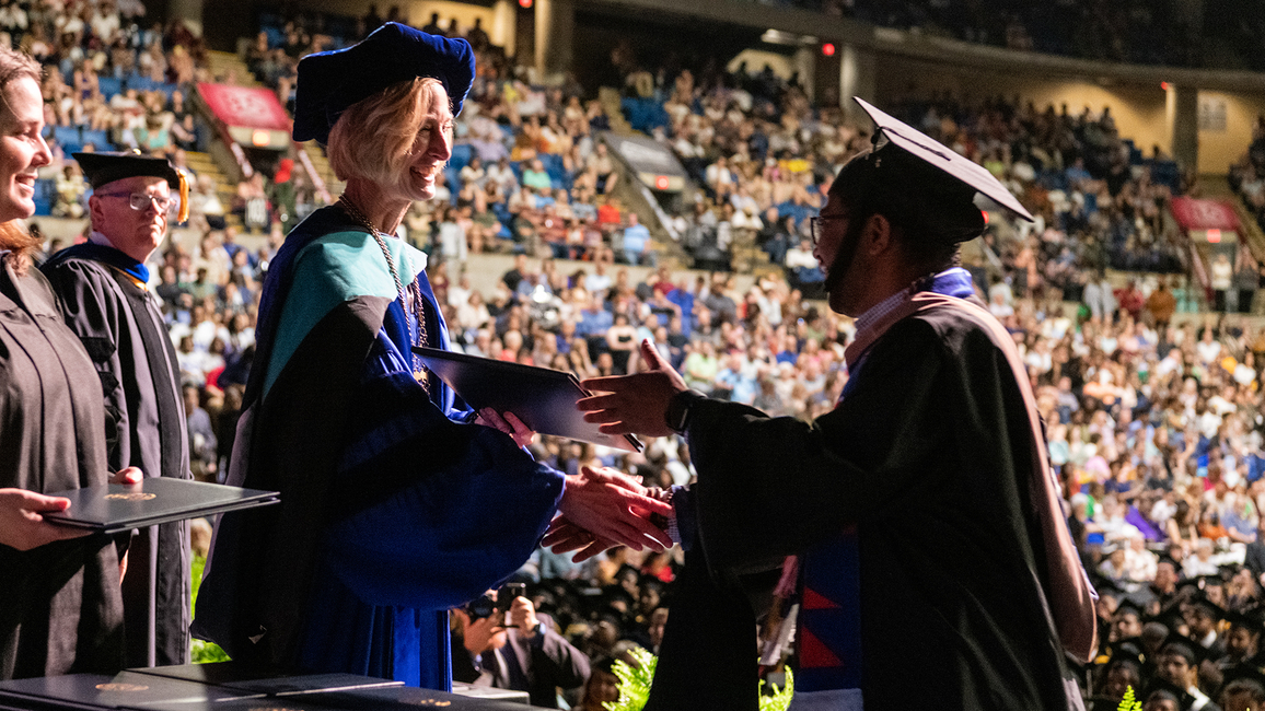 Chancellor Gooch shaking grads hand