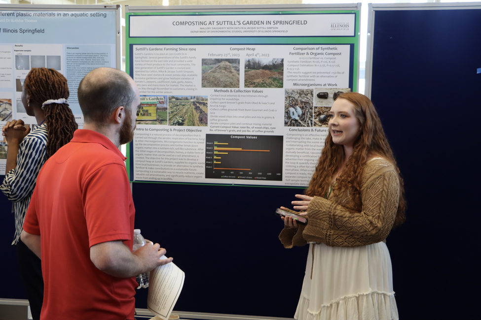 A student presenting her project to an attendee during the STARS Symposium 2023