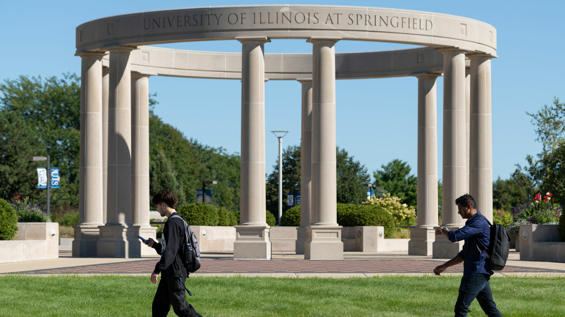 two UIS students walking in front of the colonnade