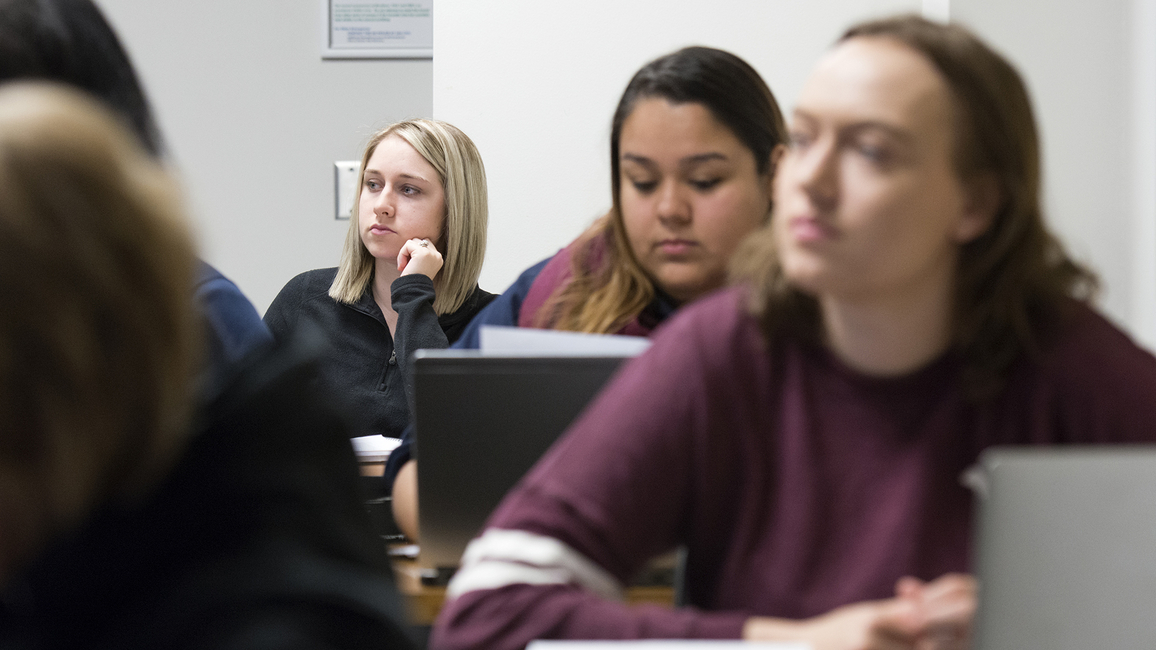 Students in a legal studies class at UIS listen to a lecture and take notes on their laptops.
