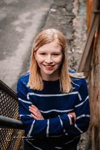 a headshot of Emma Domescik-Rink posing on stairs