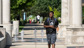 student in front of colonnade