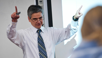 a male teacher teaching at the front of the classroom