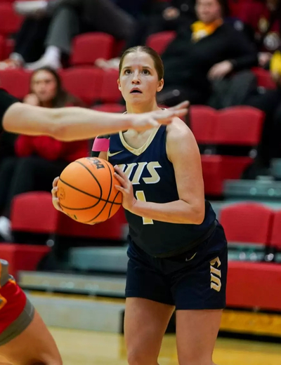 Brynn Tabeling playing basketball in blue UIS uniform