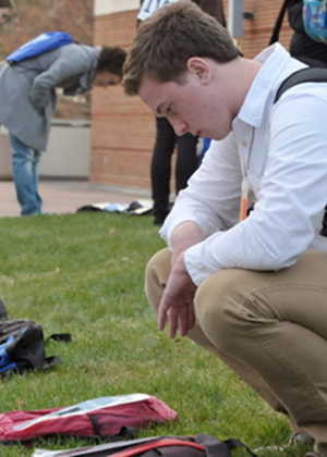 Student looking at a backpack on the ground