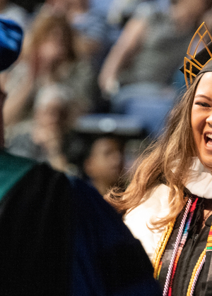 student joyfully receiving her diploma from professor