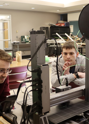 Students working on a 3D printer in the lab