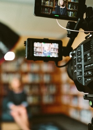 Photo of news camera man filming an interview