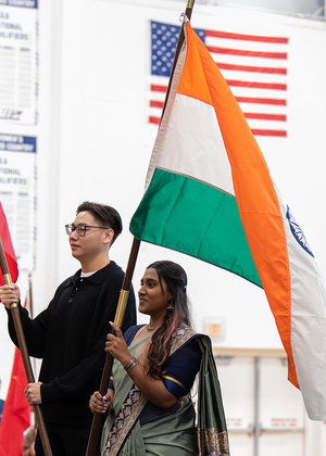 Students holding flags on stage