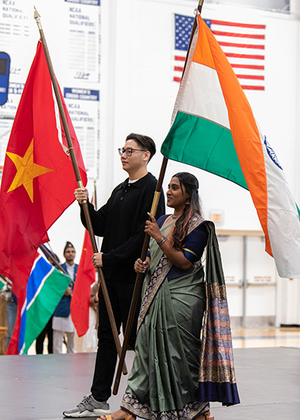 Students holding flags on stage