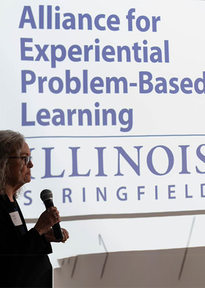 Alliance for Experiential Problem-Based Learning logo on a screen with Betsy Goulet talking